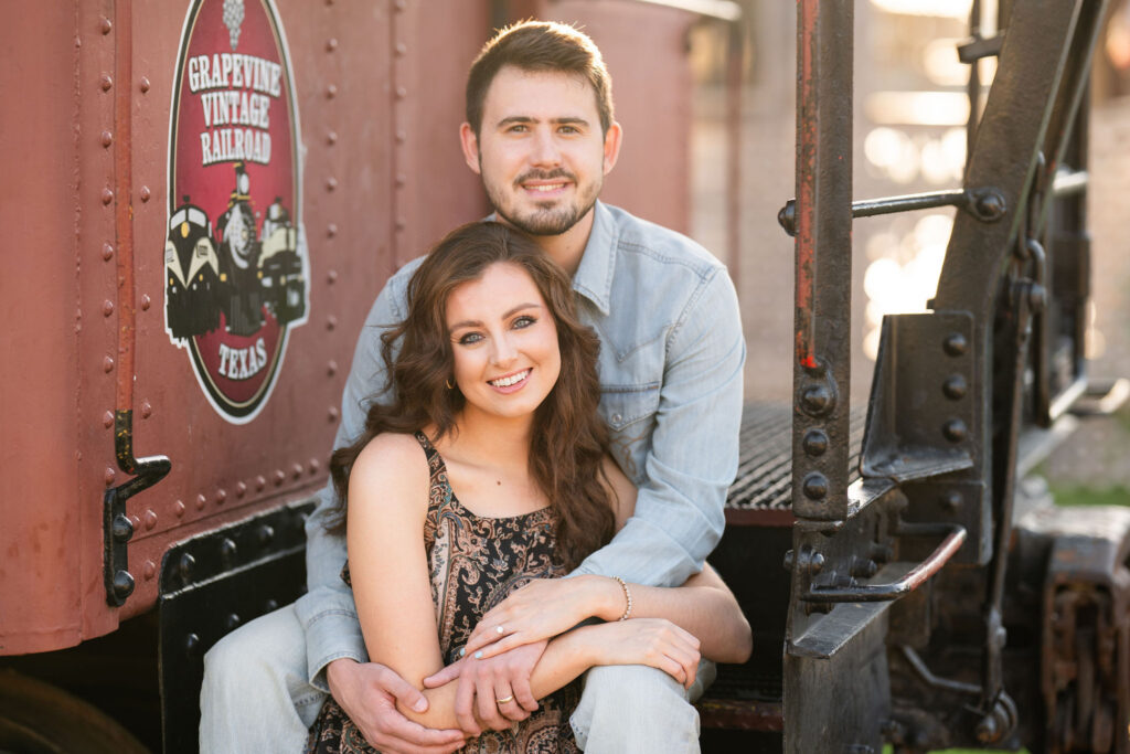 Couple seated together on the Grapevine Vintage Railroad during a sunrise photo session in Fort Worth