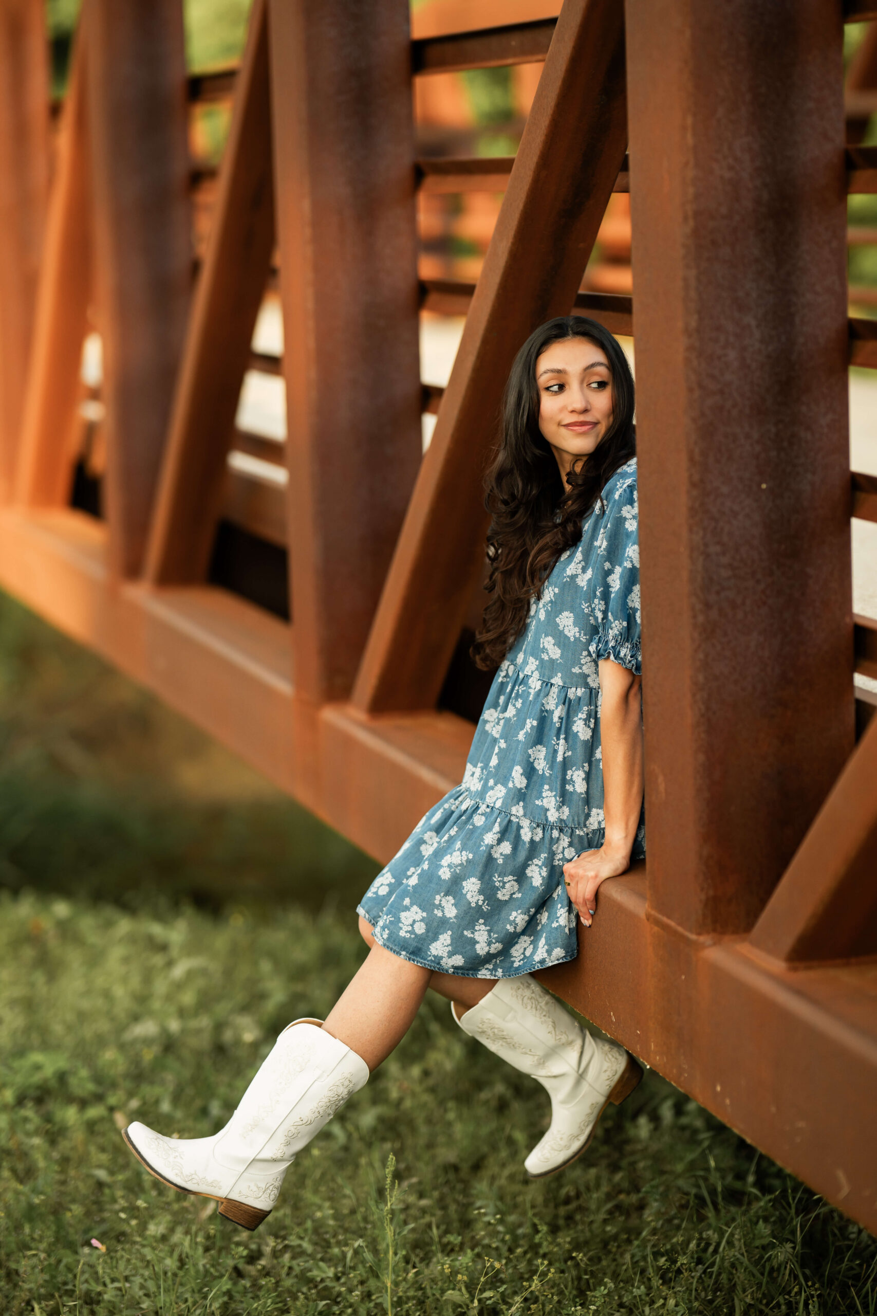 Woman in a blue floral dress near a rustic bridge in Keller, one of the featured family photo locations
