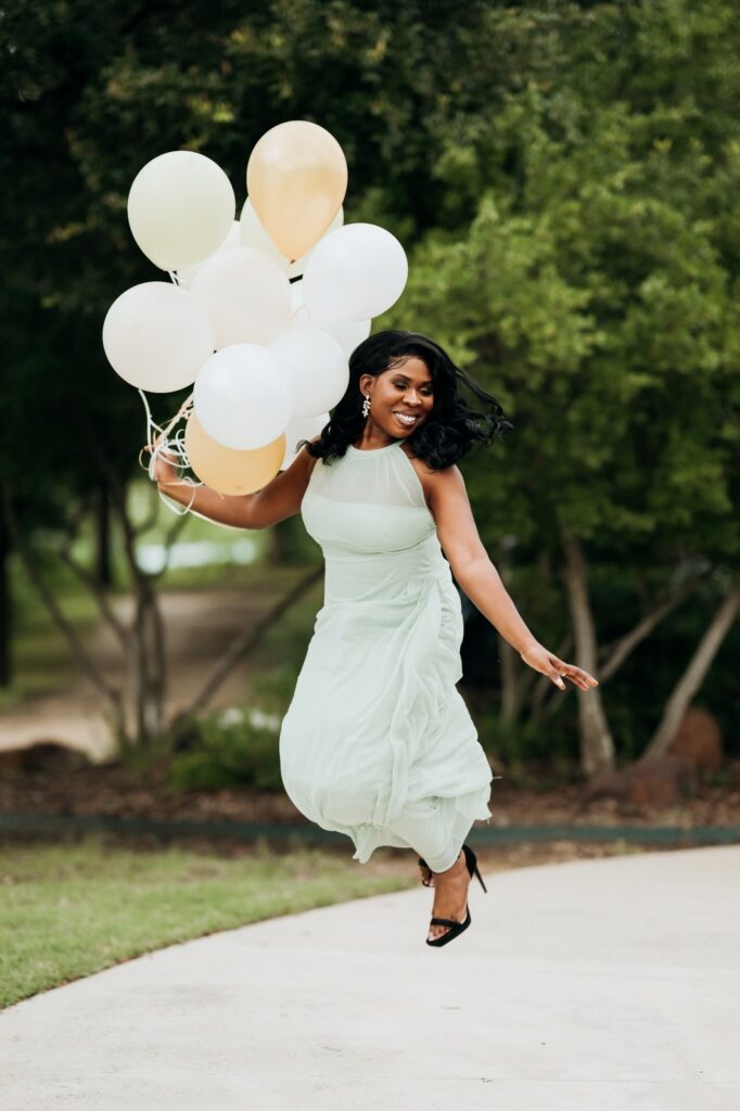Woman jumping with balloons during a joyful Keller birthday photoshoot